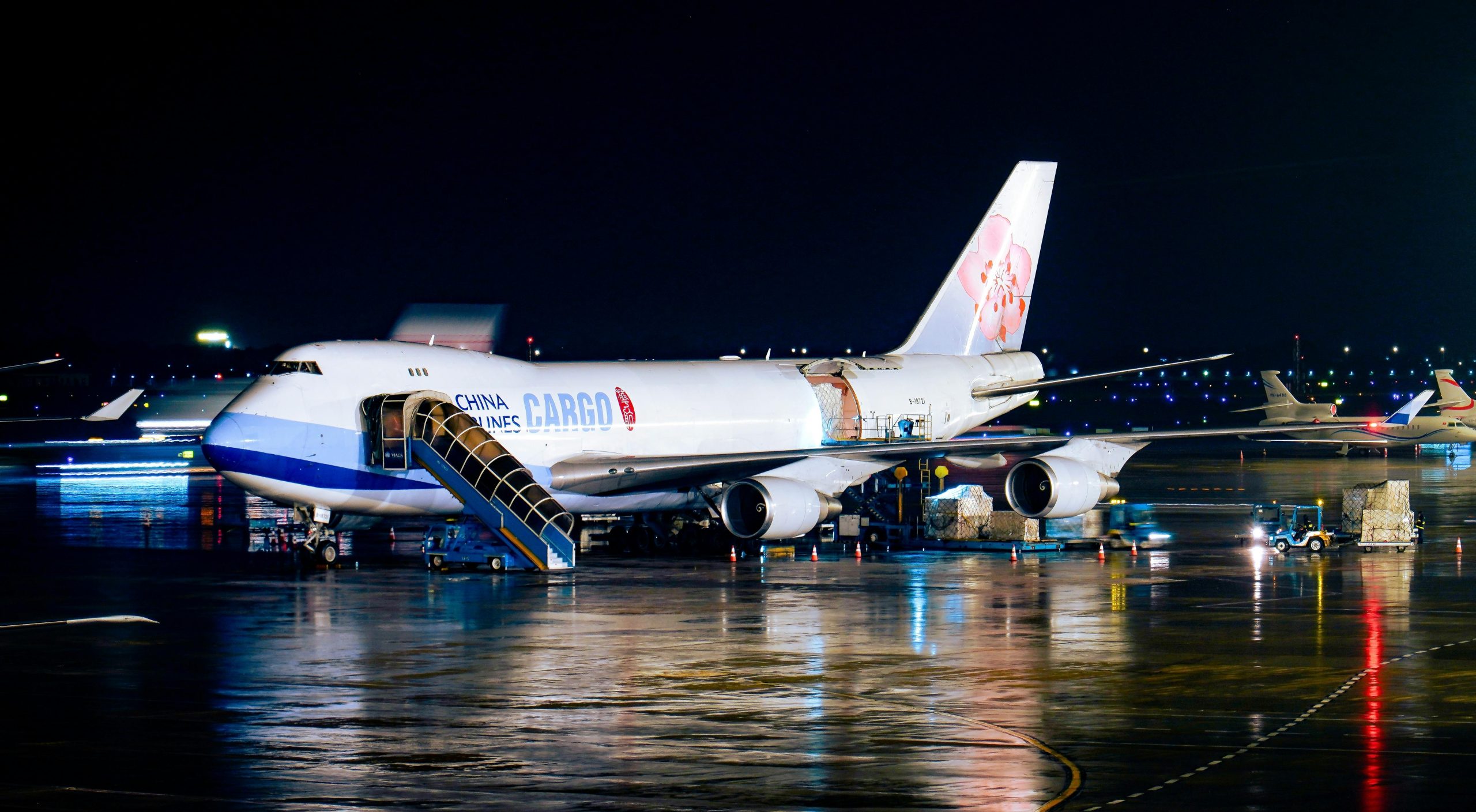 Home A China Airlines cargo plane being loaded at night with visible airport operations.